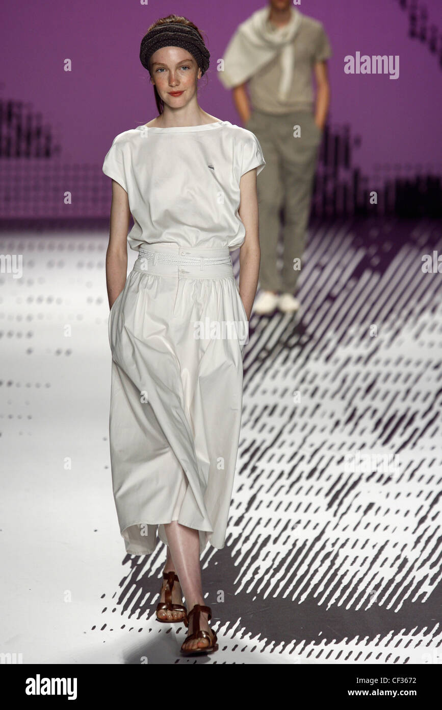 Model wearing a white mid calf length oversized dress with capped ...