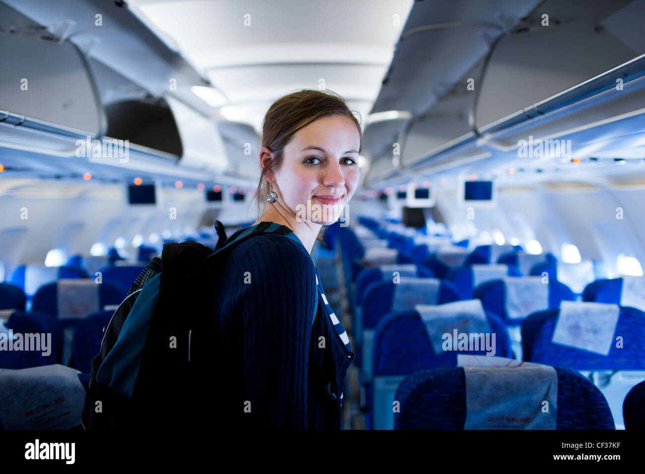 Pretty young female passenger on board of an aircraft (color toned ...