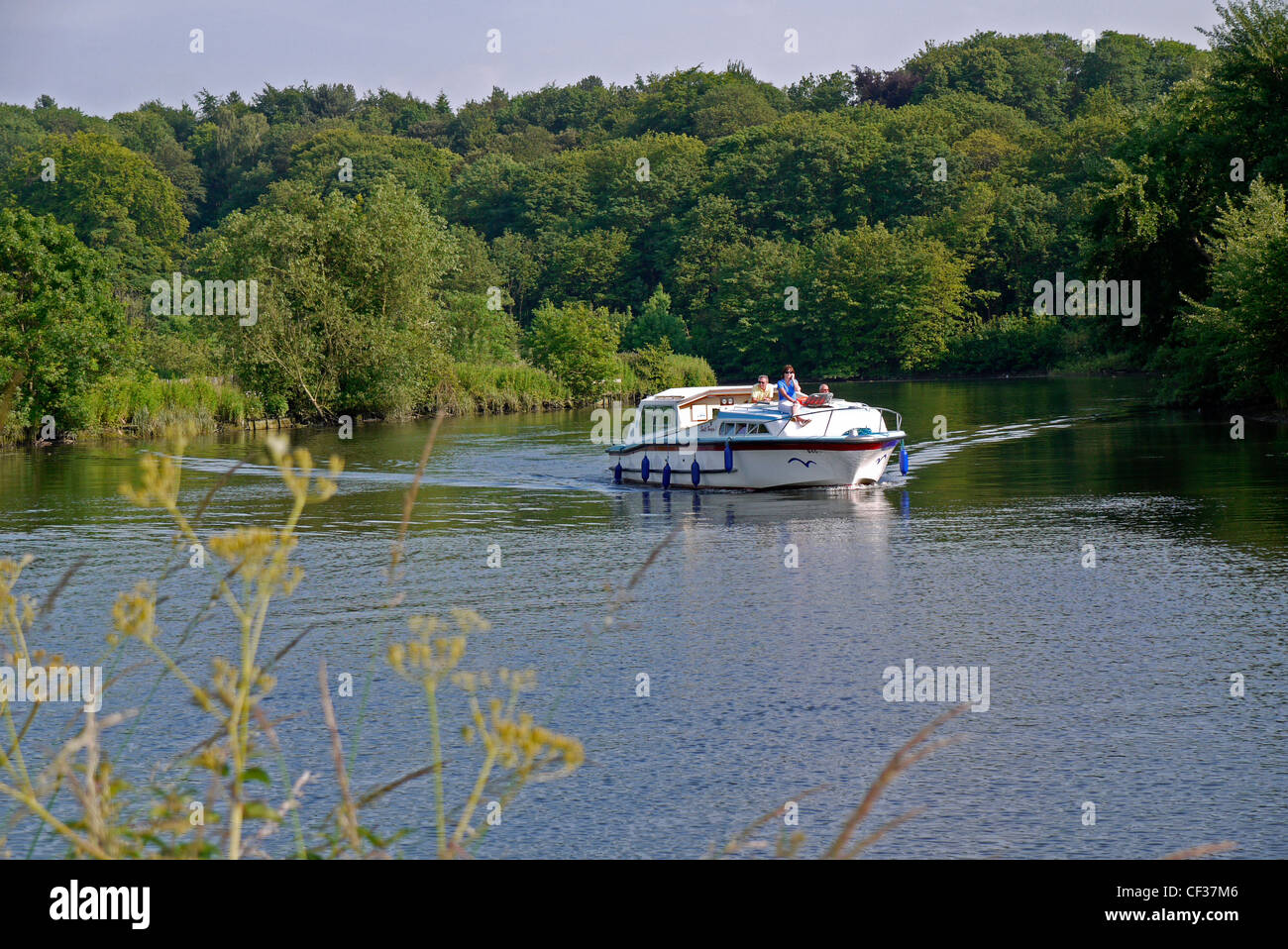 Boating along the River Yare, on the Norfolk Broads. Stock Photo