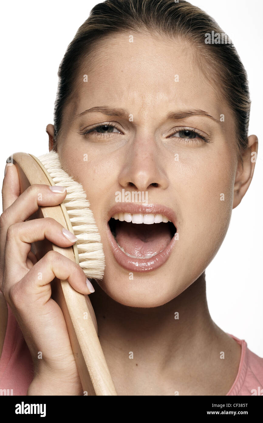 Female scrubbing face with body brush Stock Photo Alamy
