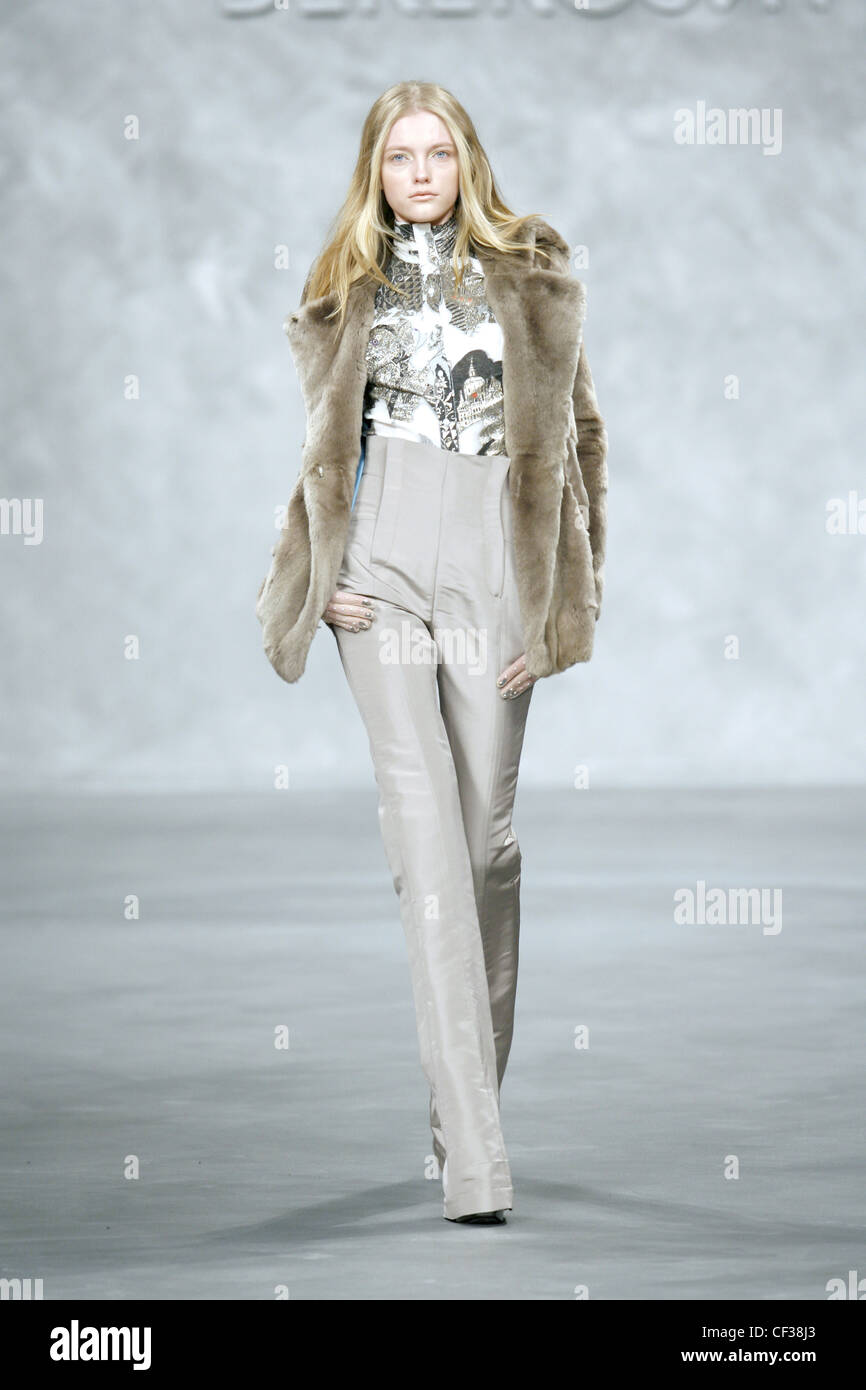 Derercuny Milan Ready to Wear Autumn Winter Model wearing fur jacket, patterned polo necked top and high waisted beige trousers Stock Photo