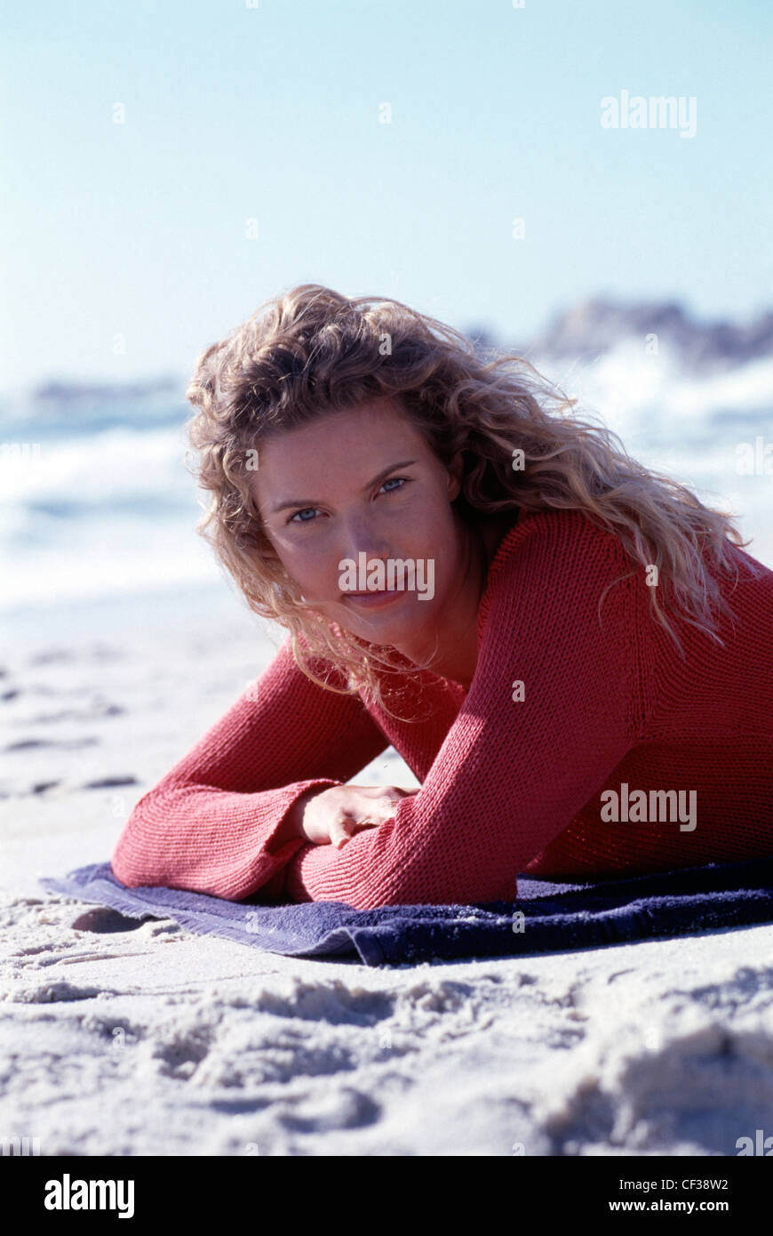 Female lying on beach on a blanket Stock Photo - Alamy