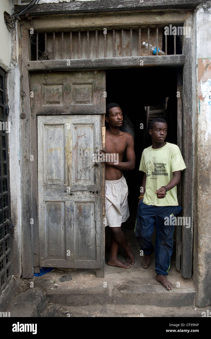 Men standing in an entrance door Stone Town Zanzibar Tanzania Stock Photo