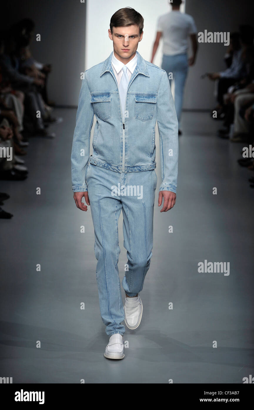 Calvin Klein Milan Ready to Wear Spring Summer Model wearing narrow legged light blue denim trousers, white shirt, light blue Stock Photo