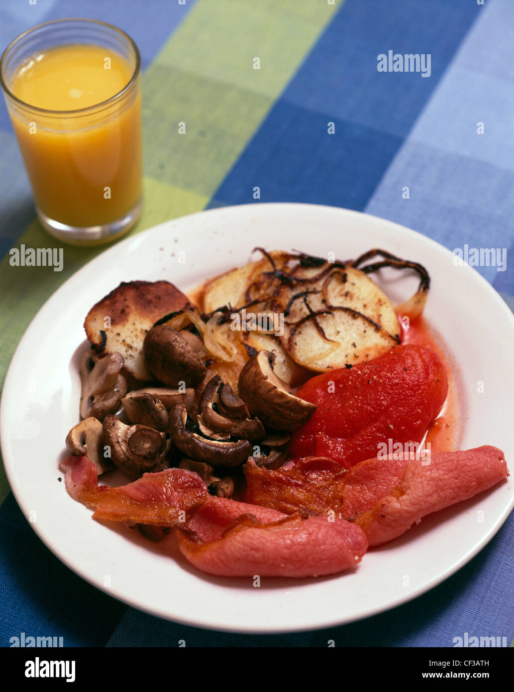 A fried breakfast mushrooms, two rashers of bacon, a tinned tomato and