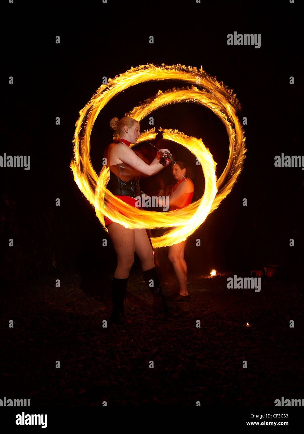 A night time view of two women spinning fire poi's at Hove in East Sussex. Stock Photo
