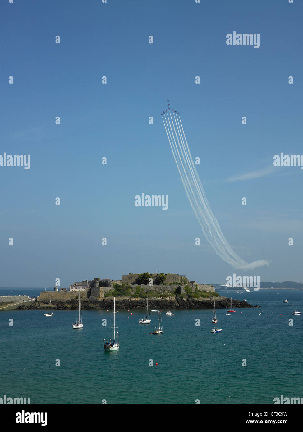 A Red Arrows display team fly in formation over Castle Cornet in Guernsey. Stock Photo