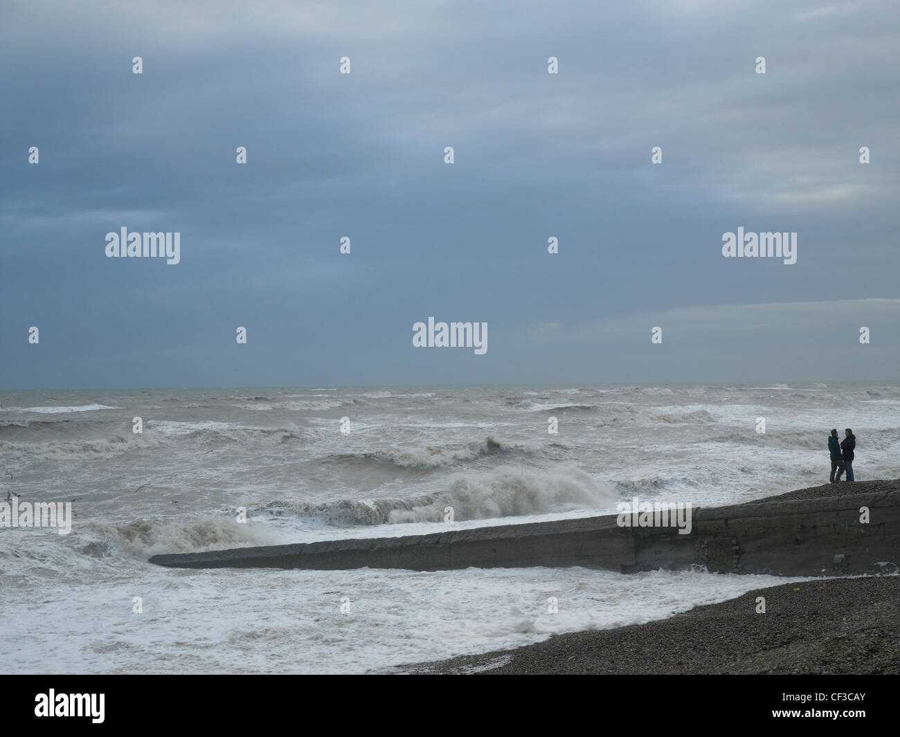 A stormy sea under grey skies with waves crashing on Brighton shore. Stock Photo