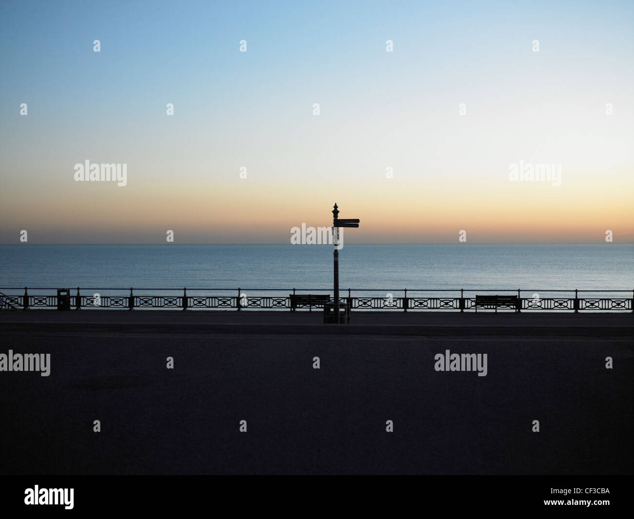 A view out to a calm sea at dusk from the promenade in Hove. Stock Photo