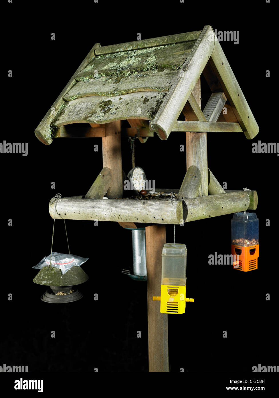 A bird table with various bird feeders hanging from it in Guernsey. Stock Photo