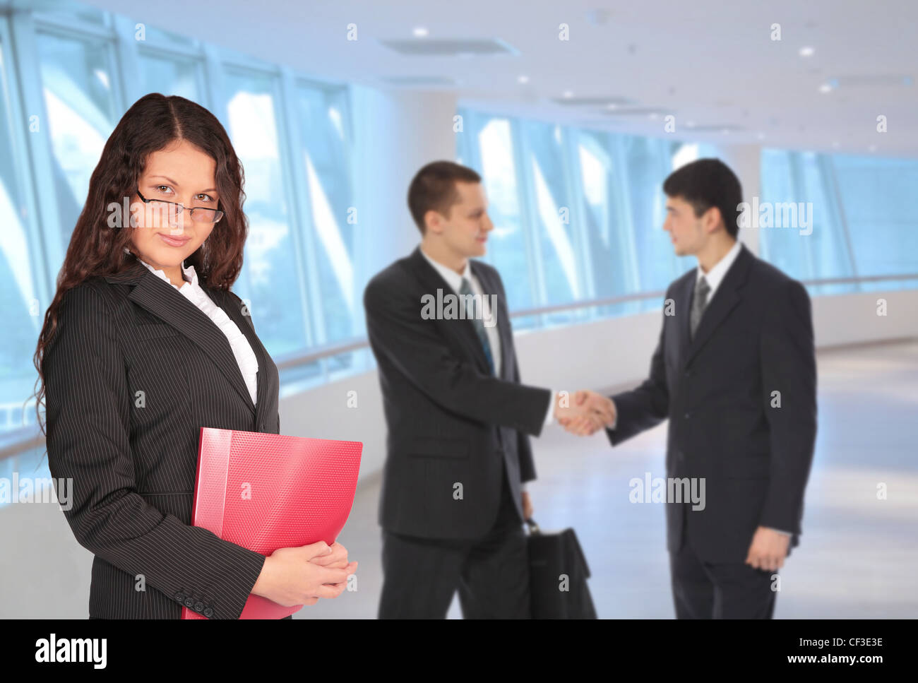 beautiful brown-haired woman with red folder and two young businessmen in bisiness center, collage Stock Photo