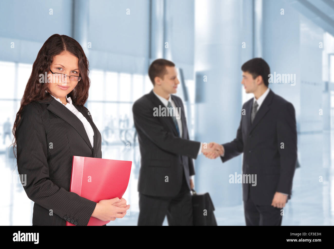 beautiful brown-haired woman with red folder and two young businessmen in bisiness center, collage Stock Photo