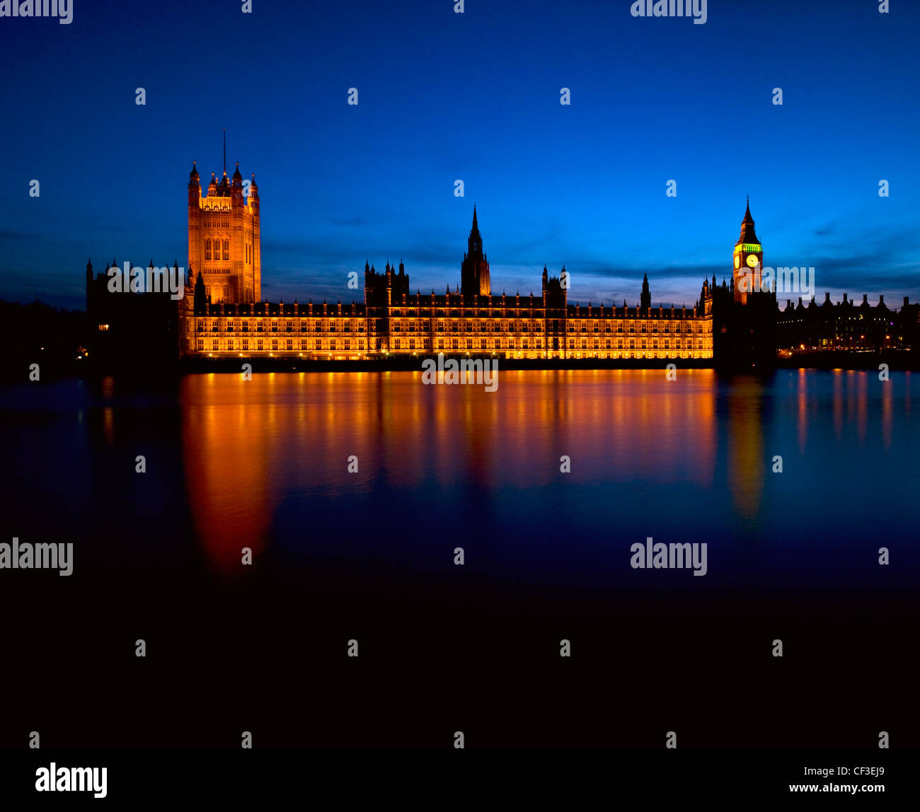 View across the River Thames to an illuminated Houses of Parliament. Stock Photo
