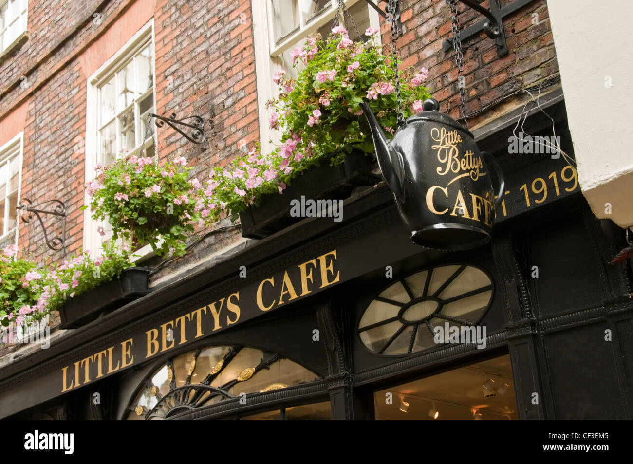 Windowsill flowers sit above the famous Bettys cafe shop front in York. Stock Photo