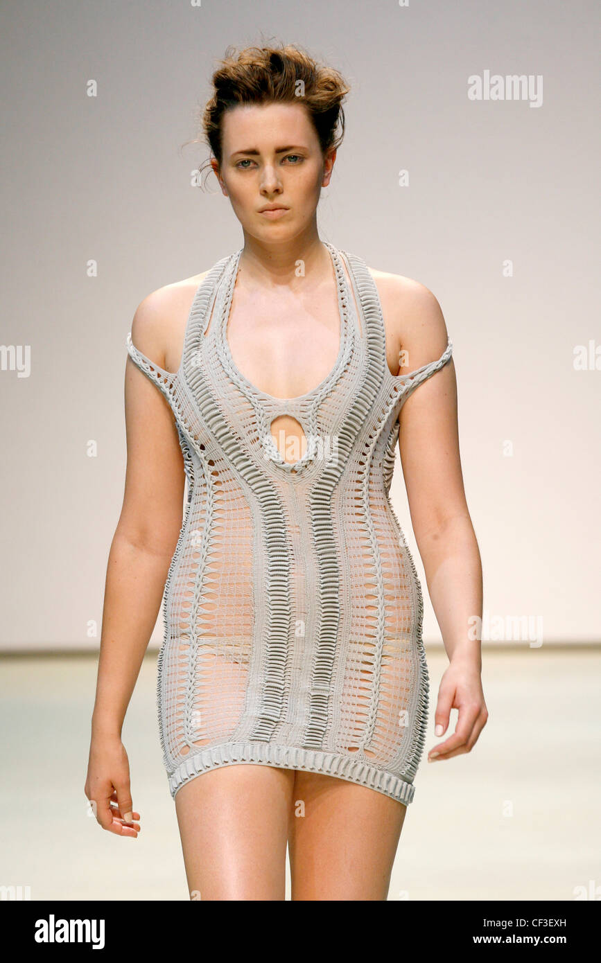 Mark Fast London Ready to Wear Spring Summer A pale grey sleeveless sheer knitted minidress with halterneck straps Stock Photo