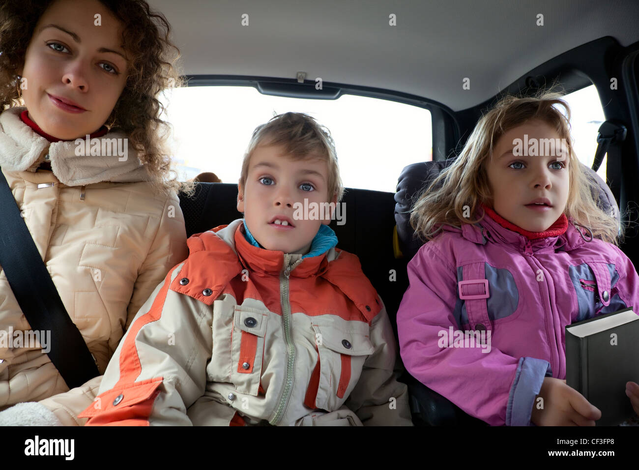 с мамой на заднем сидении. мама с детьми и автомобиль. маленький ребёнок на заднем сидении. Children in the back seat of the car. детские сиденья в автомобиль.