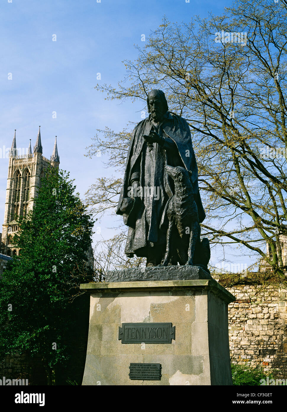 Cast bronze by George Frederick Watts of poet laureate Alfred, Lord Tennyson in Minster Yard with one of the cathedral's western Stock Photo