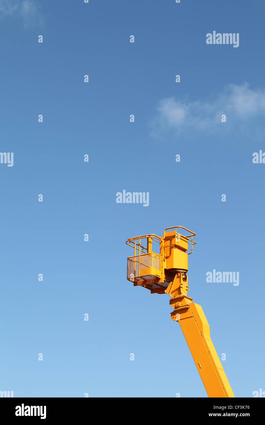 Yellow cherry picker against a blue sky Stock Photo