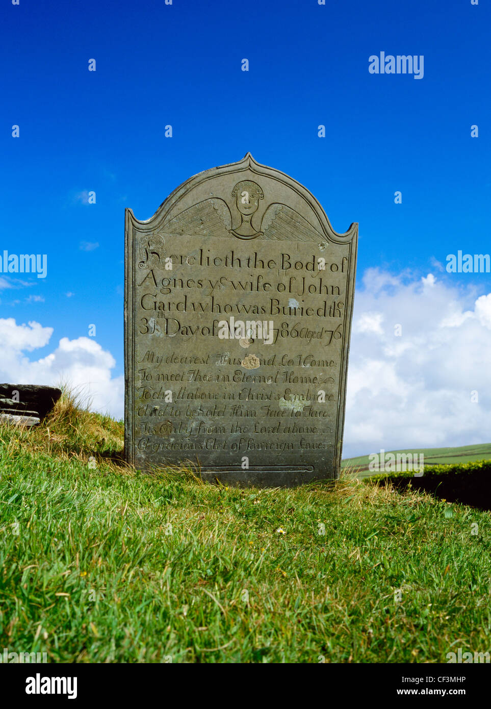 A Georgian headstone, decorated with an angel, stands beside the path to St Symphorian's church on Forrabury Common above Boscas Stock Photo