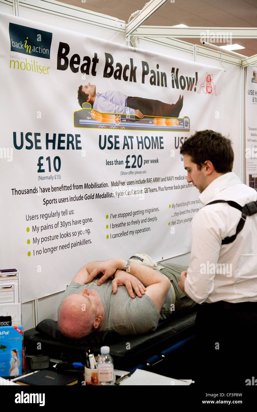 A man having back pain treatment from a therapist using the mobiliser bed, the Back Pain show London UK Stock Photo