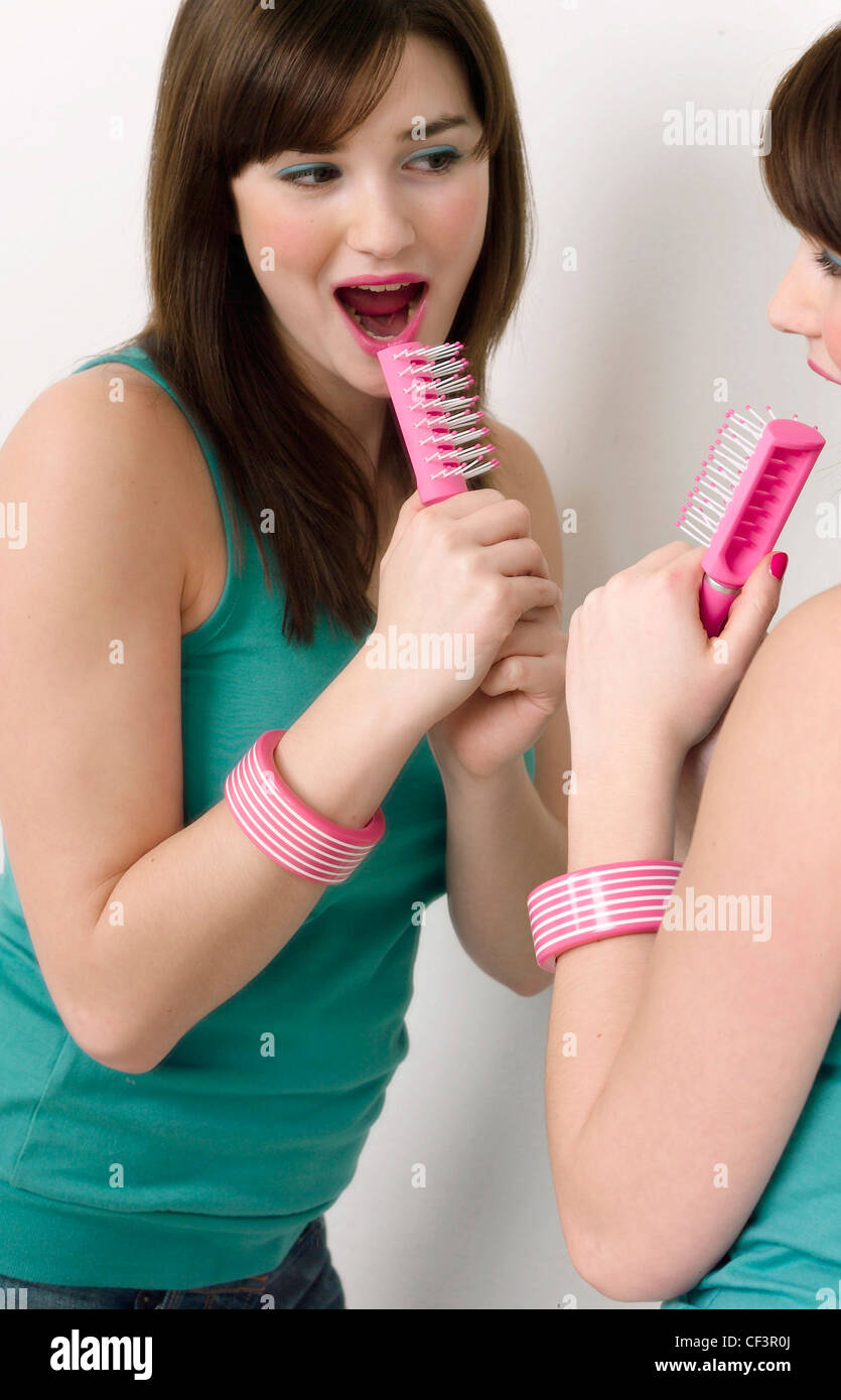 Girl singing into hairbrush hi-res stock photography and images - Alamy