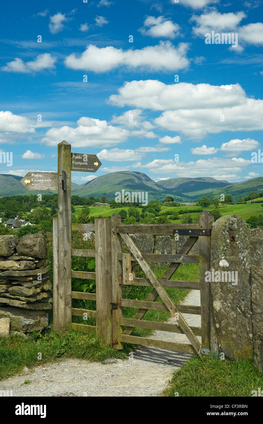 A directional public footpath sign by a gate on a path in the Lake ...