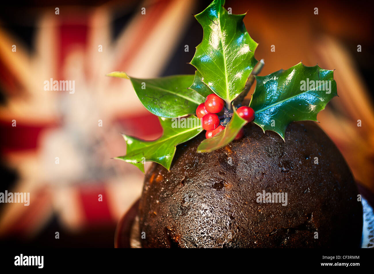 A delicious Christmas pudding with Holly and berries inserted in the top. Stock Photo