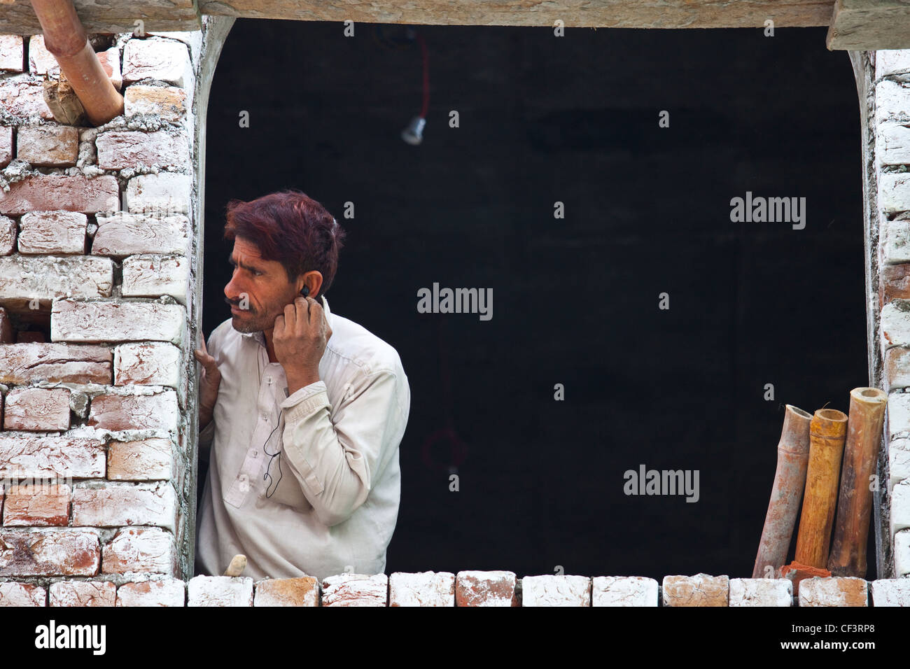 Workman listening to music in Lahore, Pakistan Stock Photo