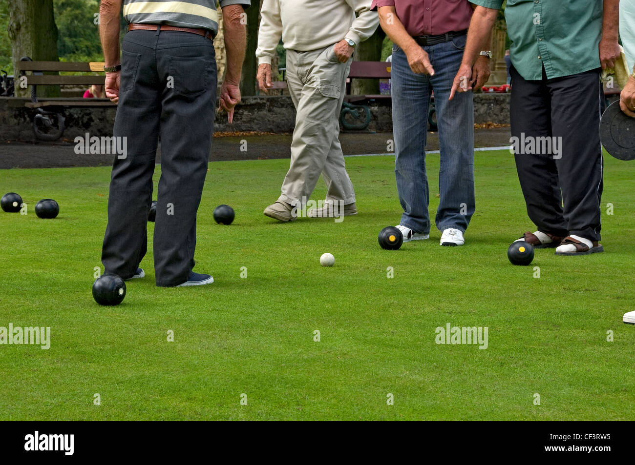 Bowlers deciding on the winner of an end in a game of Crown Green Bowls. Stock Photo