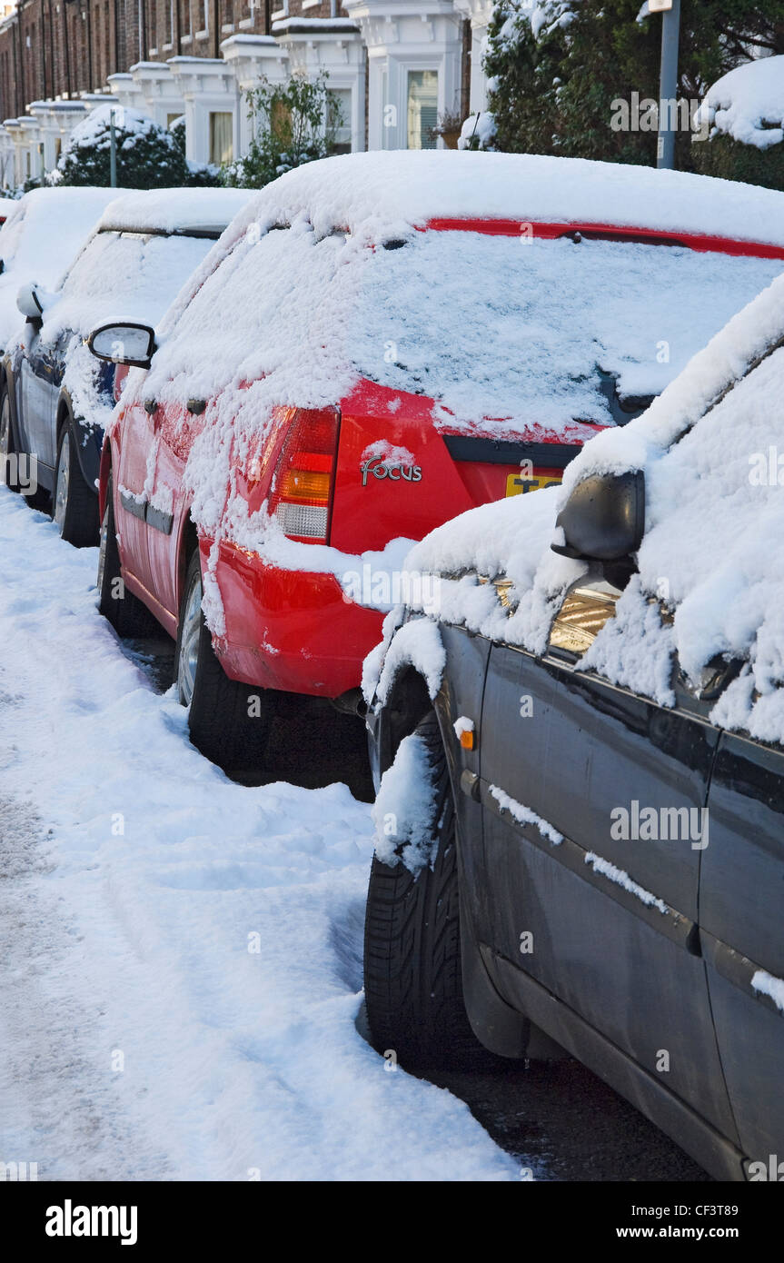 A row of snow covered cars parked along a street in York Stock Photo ...