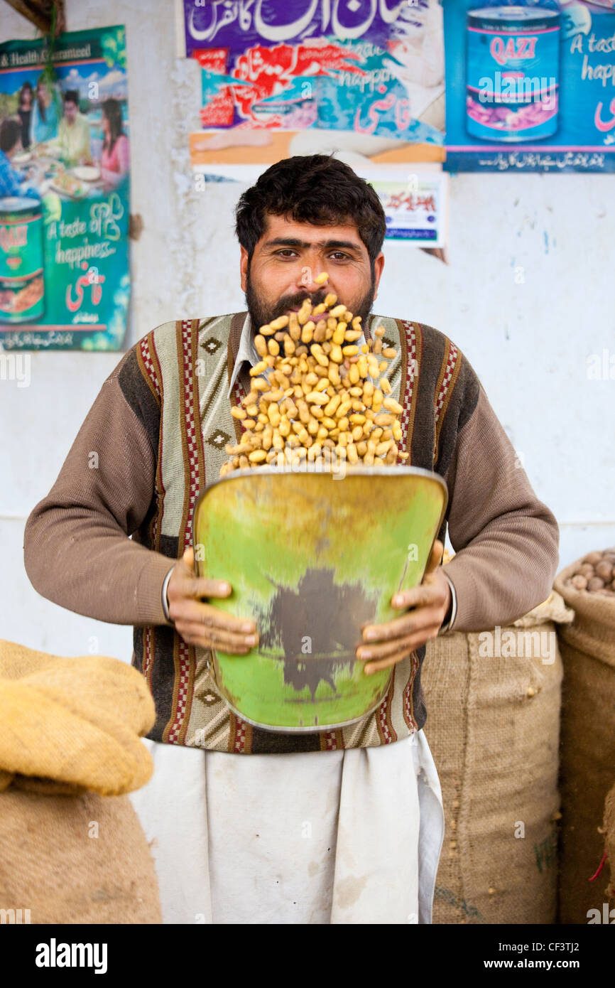 Nut vendor removing loose shells from peanuts, Islamabad, Pakistan Stock Photo
