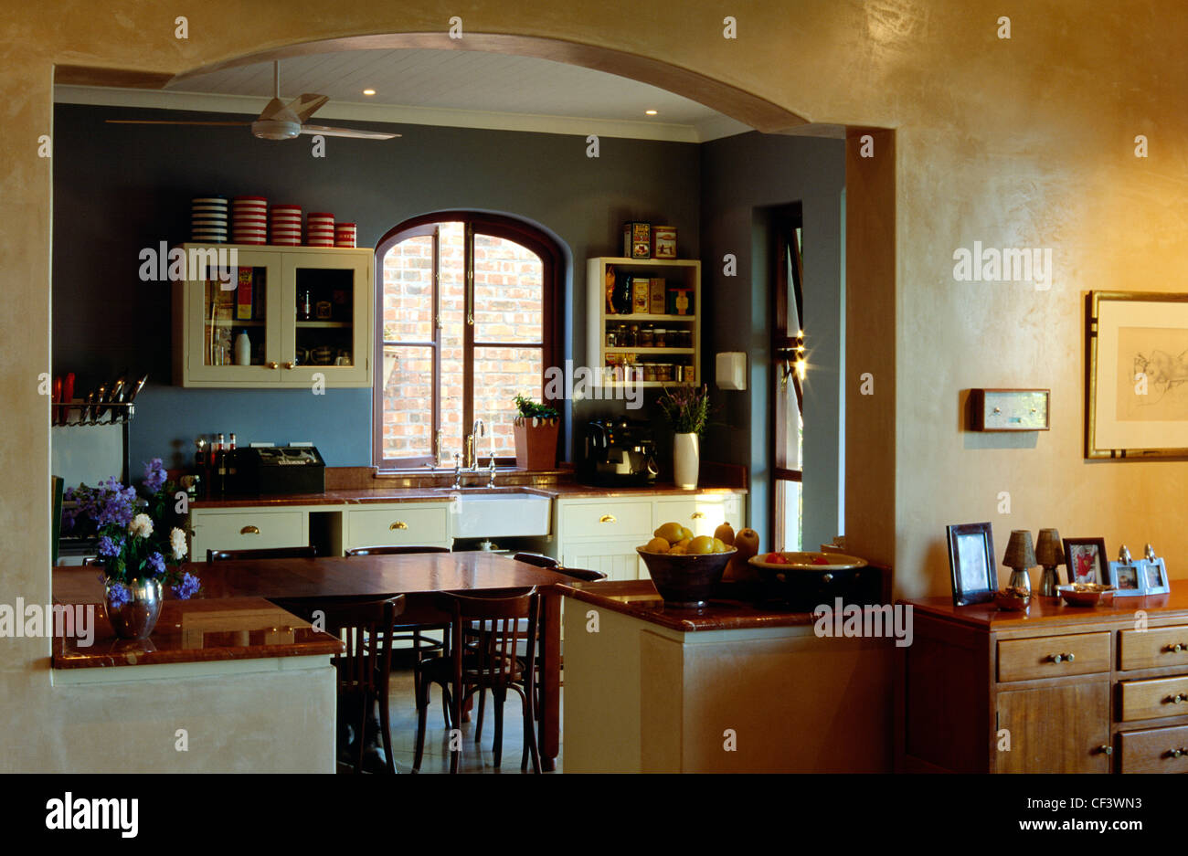 View Through Arch Of Kitchen Dark Blue And Dark Yellow Walls