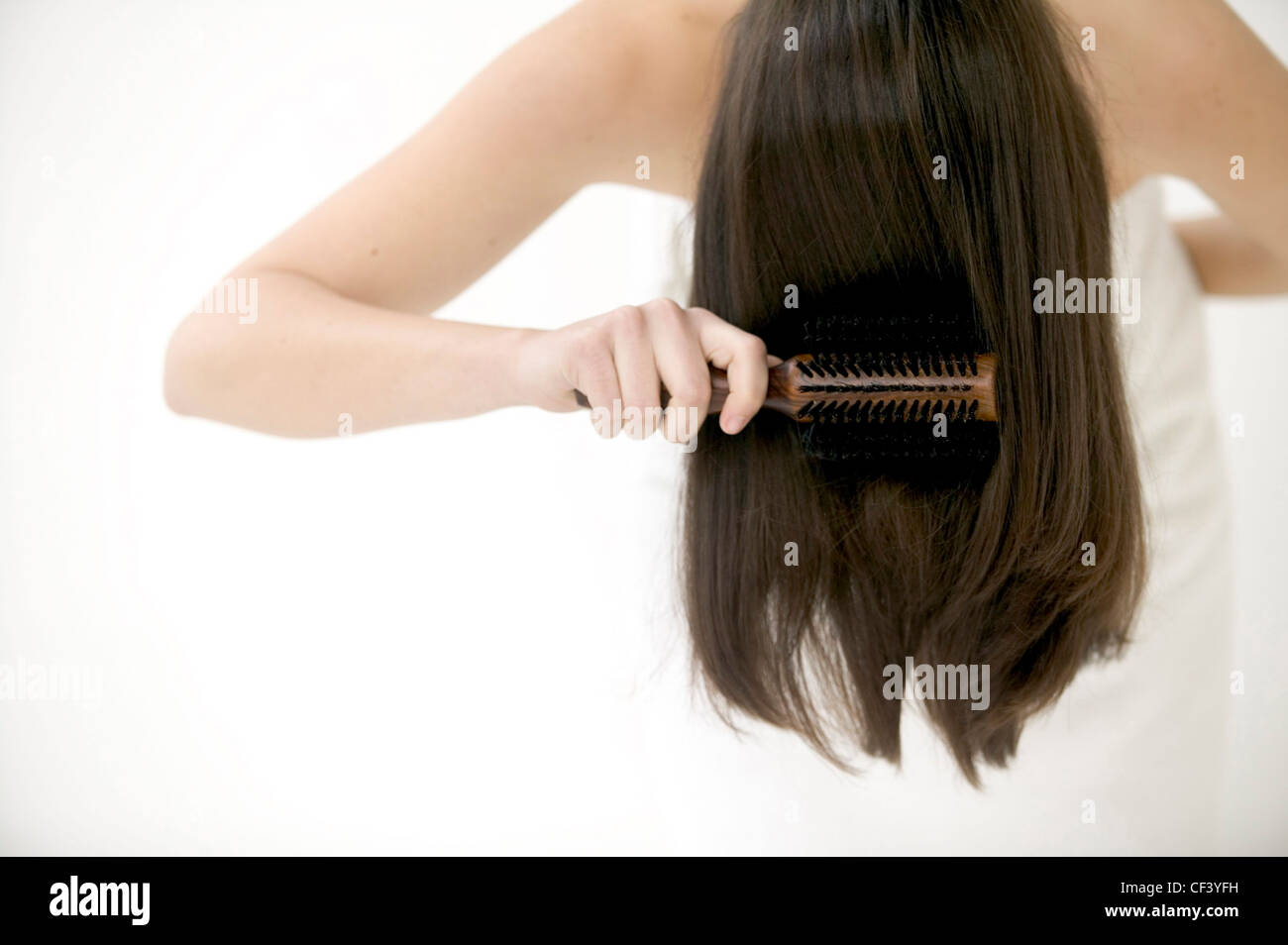 Female Wrapped In White Towel Bending Forward Brushing Long