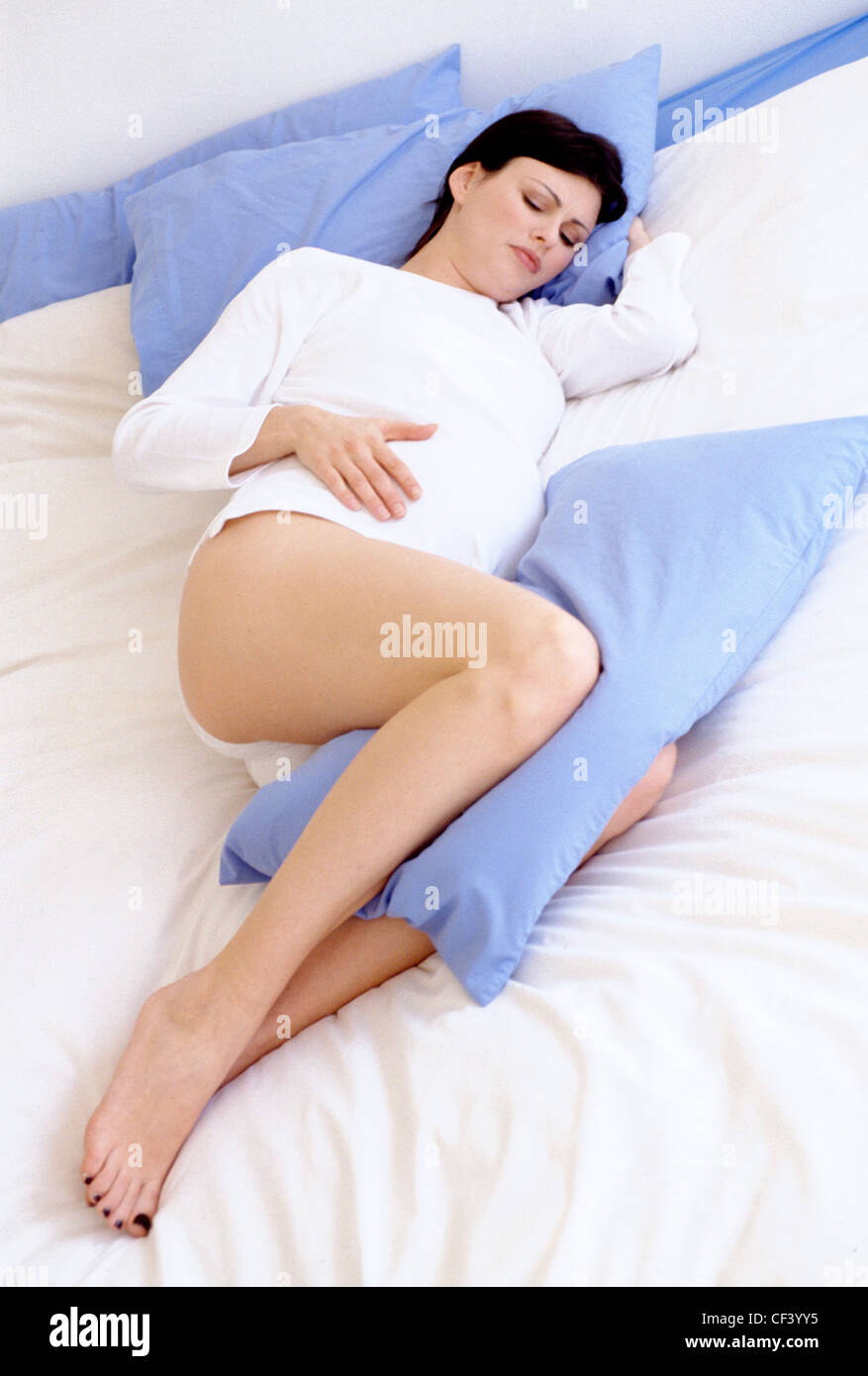 Sleeping with pillow between legs hi-res stock photography and