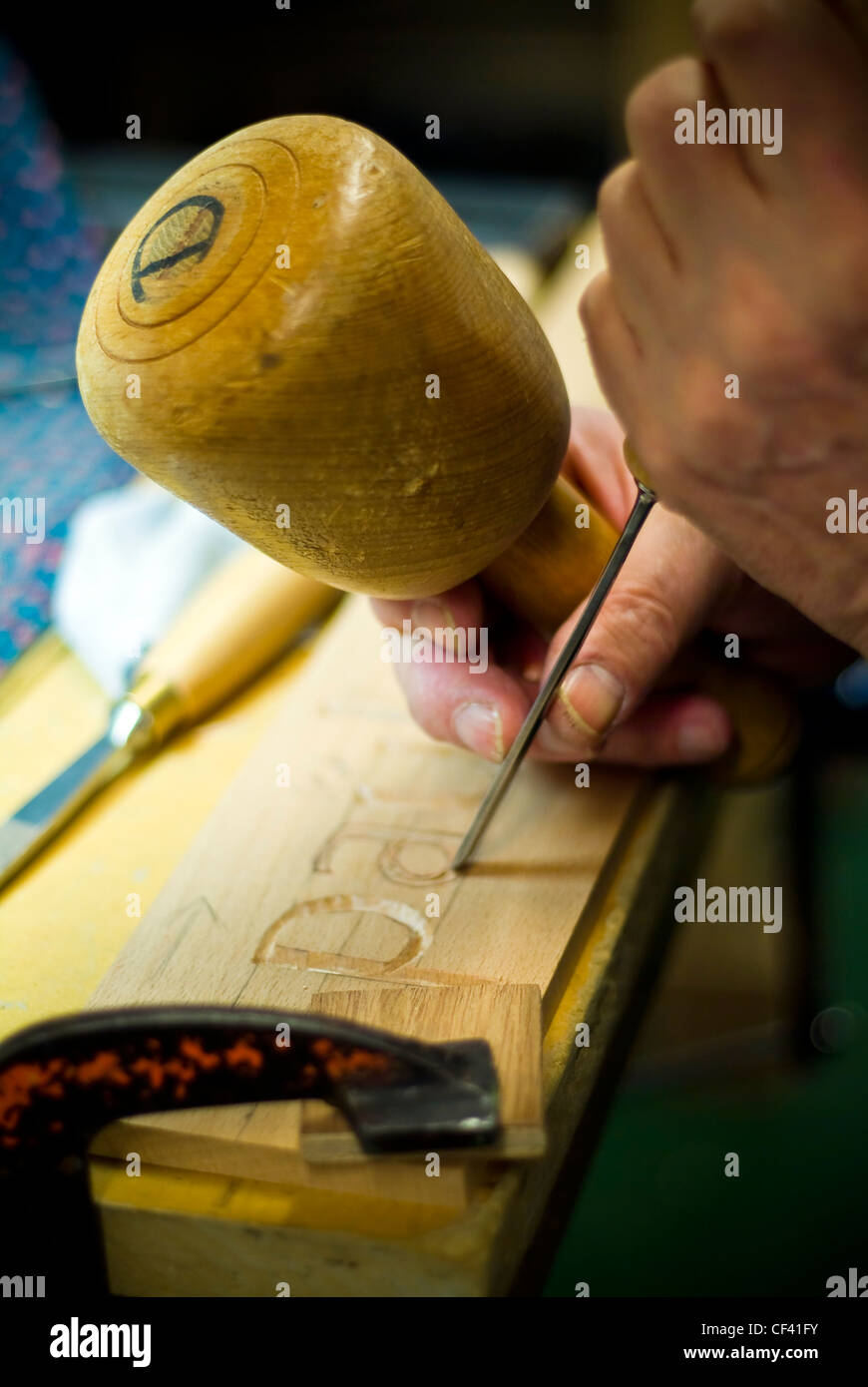 Craftsman carving lettering into wood with a chisel Stock Photo - Alamy