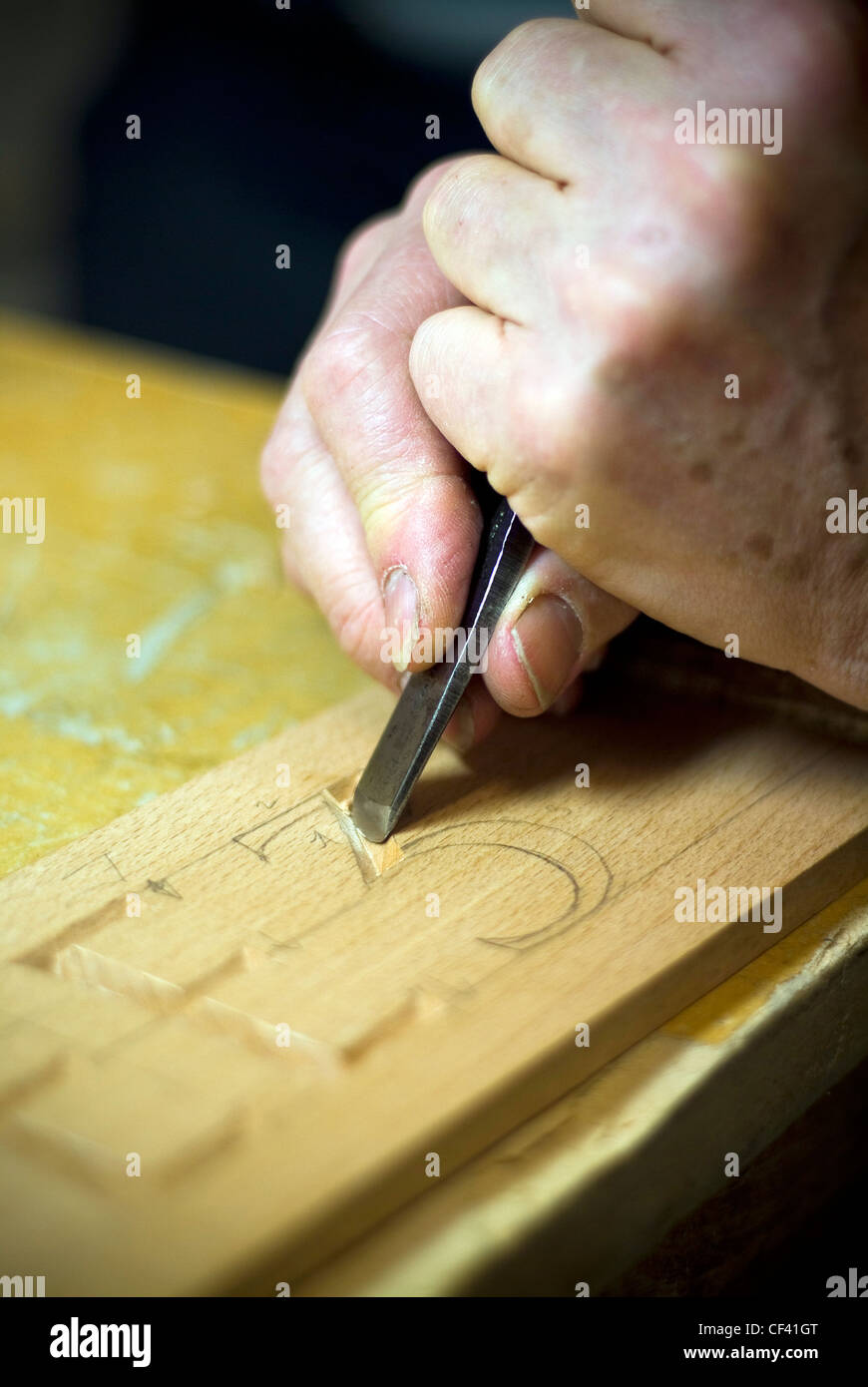 Craftsman carving lettering into wood with a chisel Stock Photo - Alamy