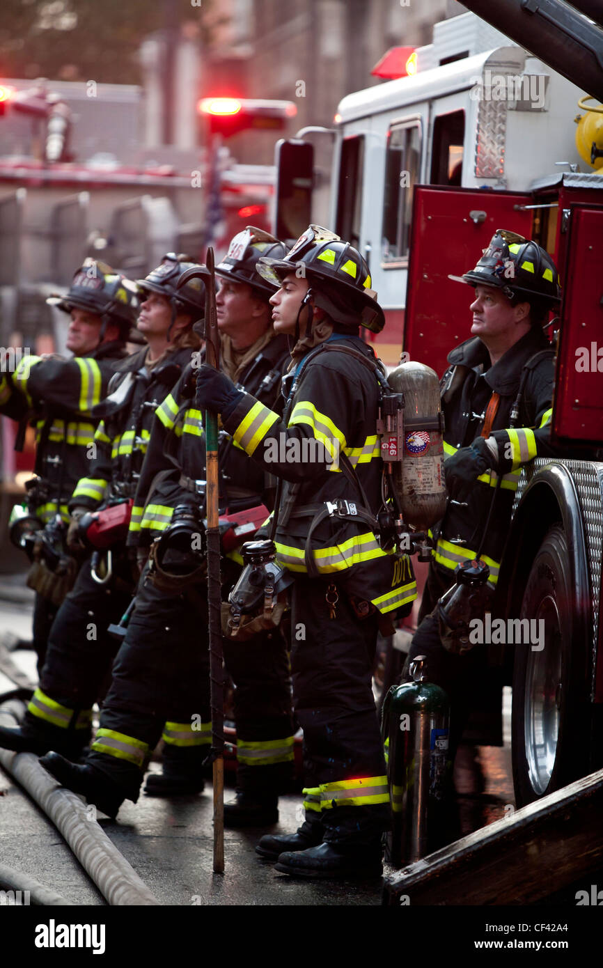New York City Firemen standing by firetruck Stock Photo