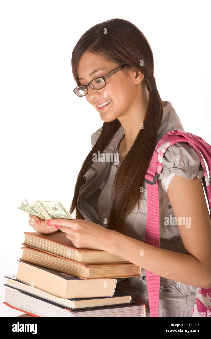 Asian young woman college student with backpack in eyeglasses and pile of books counting money Stock Photo