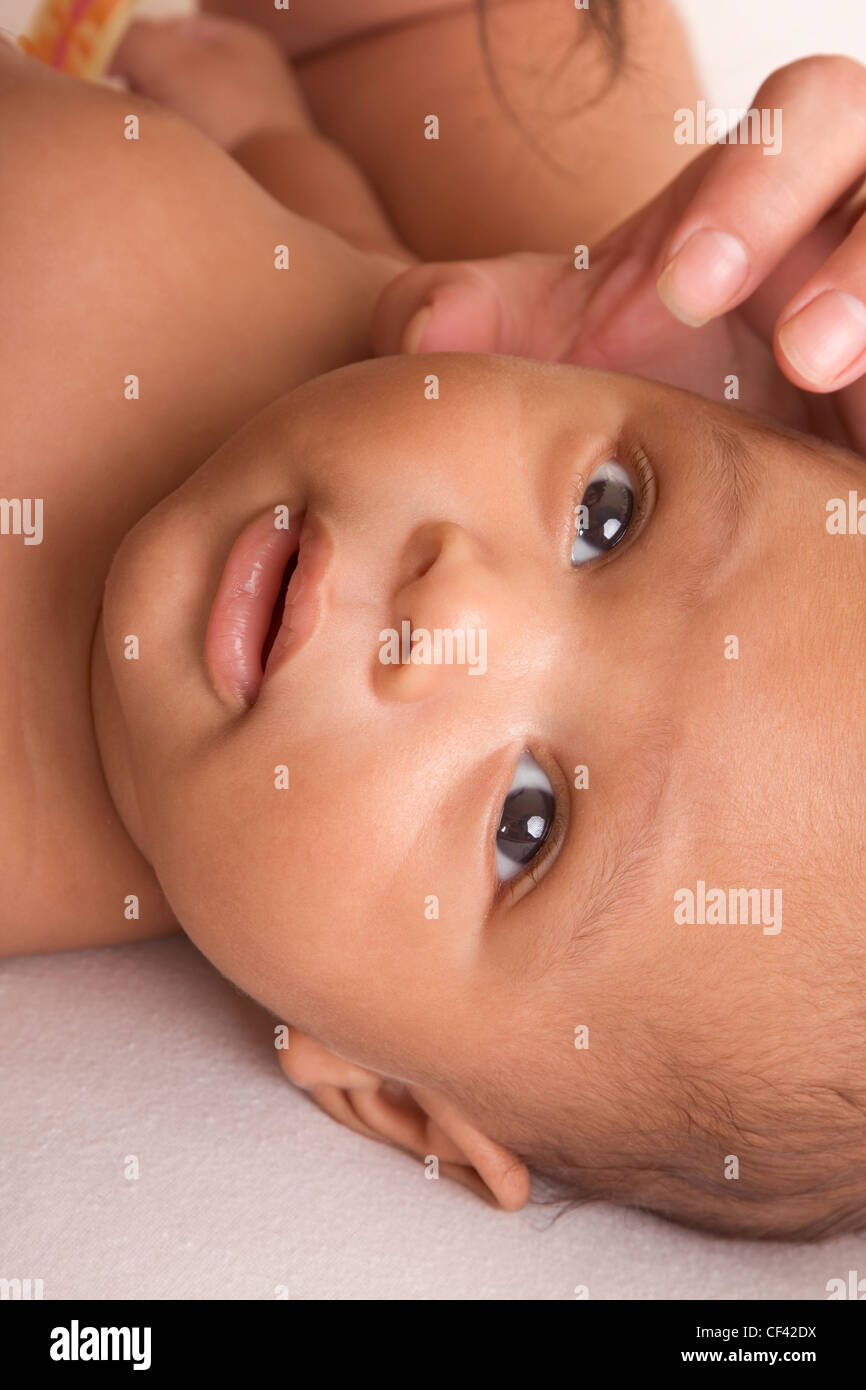 biracial mix of Hispanic and black African American infant lying down. Baby is almost 2 month (7 weeks old) Stock Photo