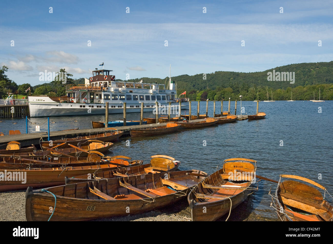 A pleasure boat and rowing boats for hire on Lake Windermere. Stock Photo