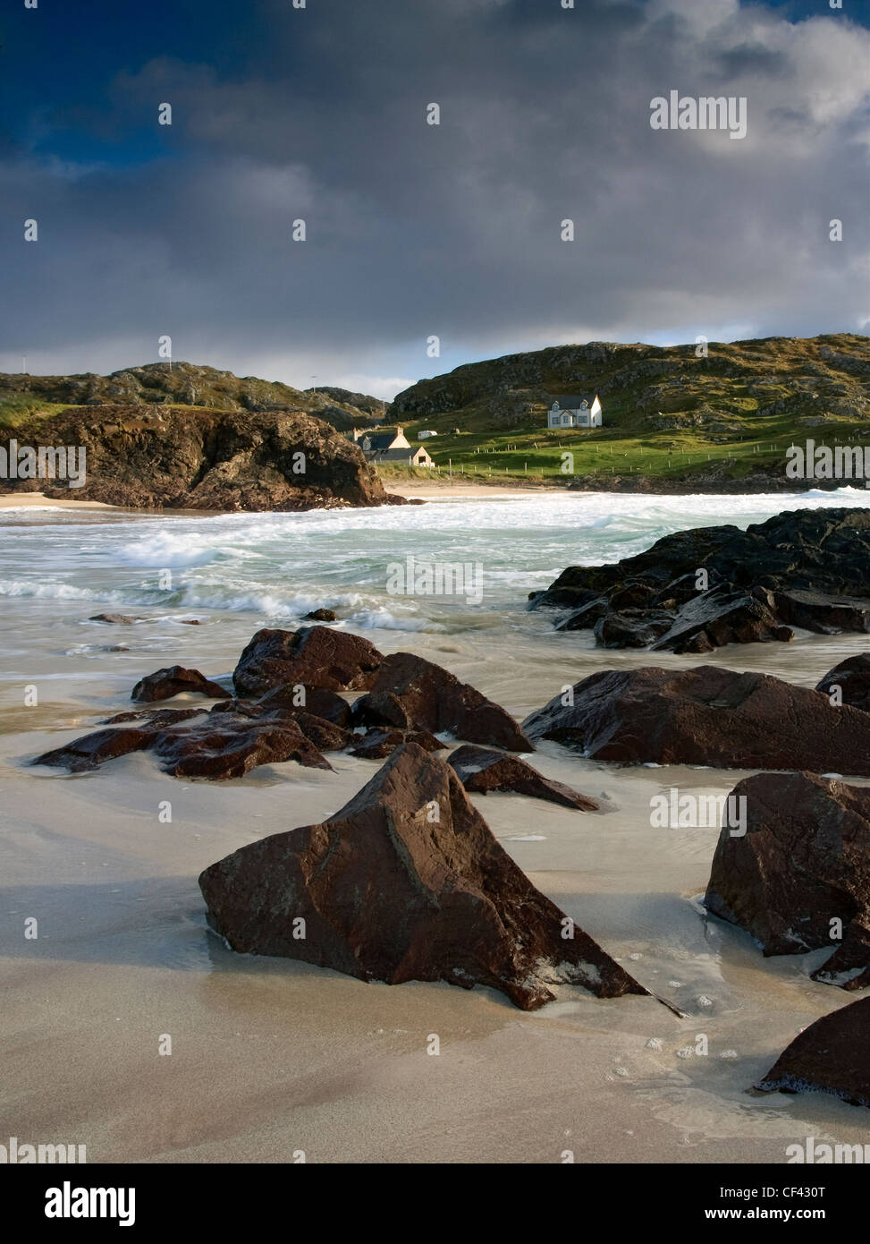 Waves roll in onto the shore during high tide at the remote and picturesque Clachtoll Bay. Stock Photo