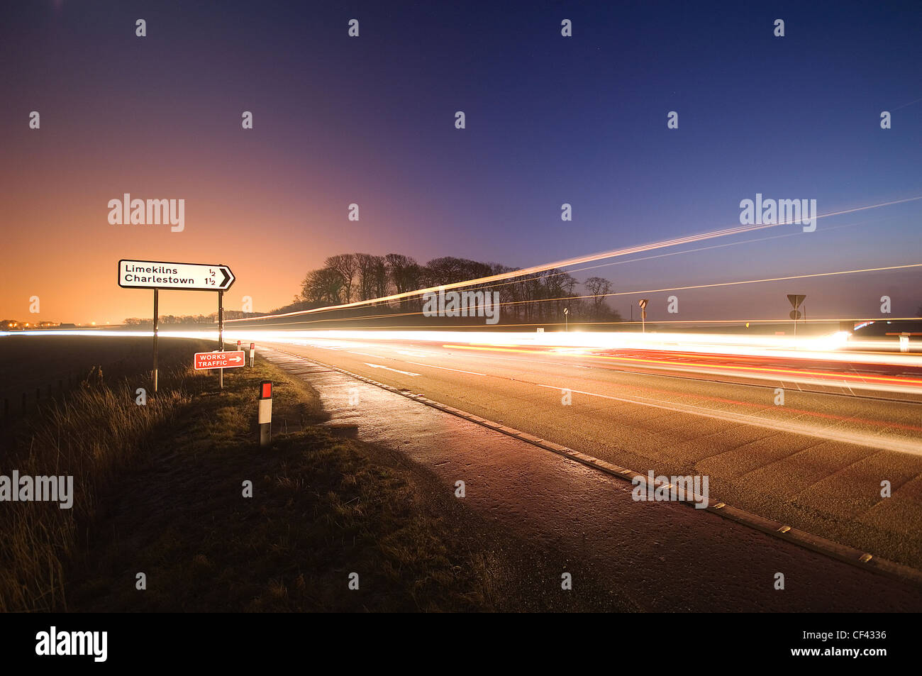 Car light trails on a road at night. Stock Photo