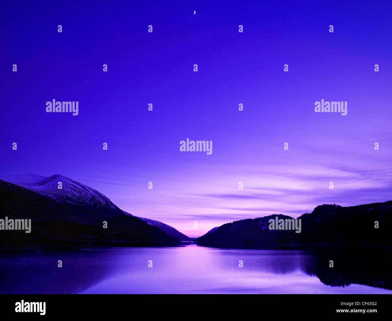 A crescent moon rises above Thirlmere as darkness descends in the Lake District Stock Photo Alamy