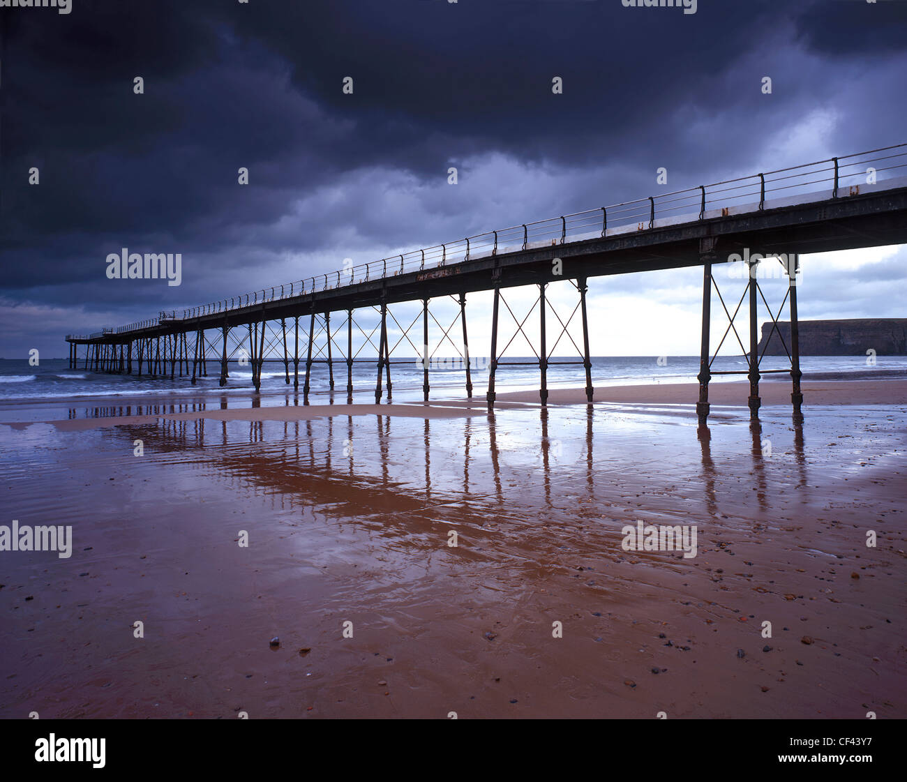 Saltburn Pier, the last pier remaining in Yorkshire, at low tide as storm clouds gather overhead. Stock Photo
