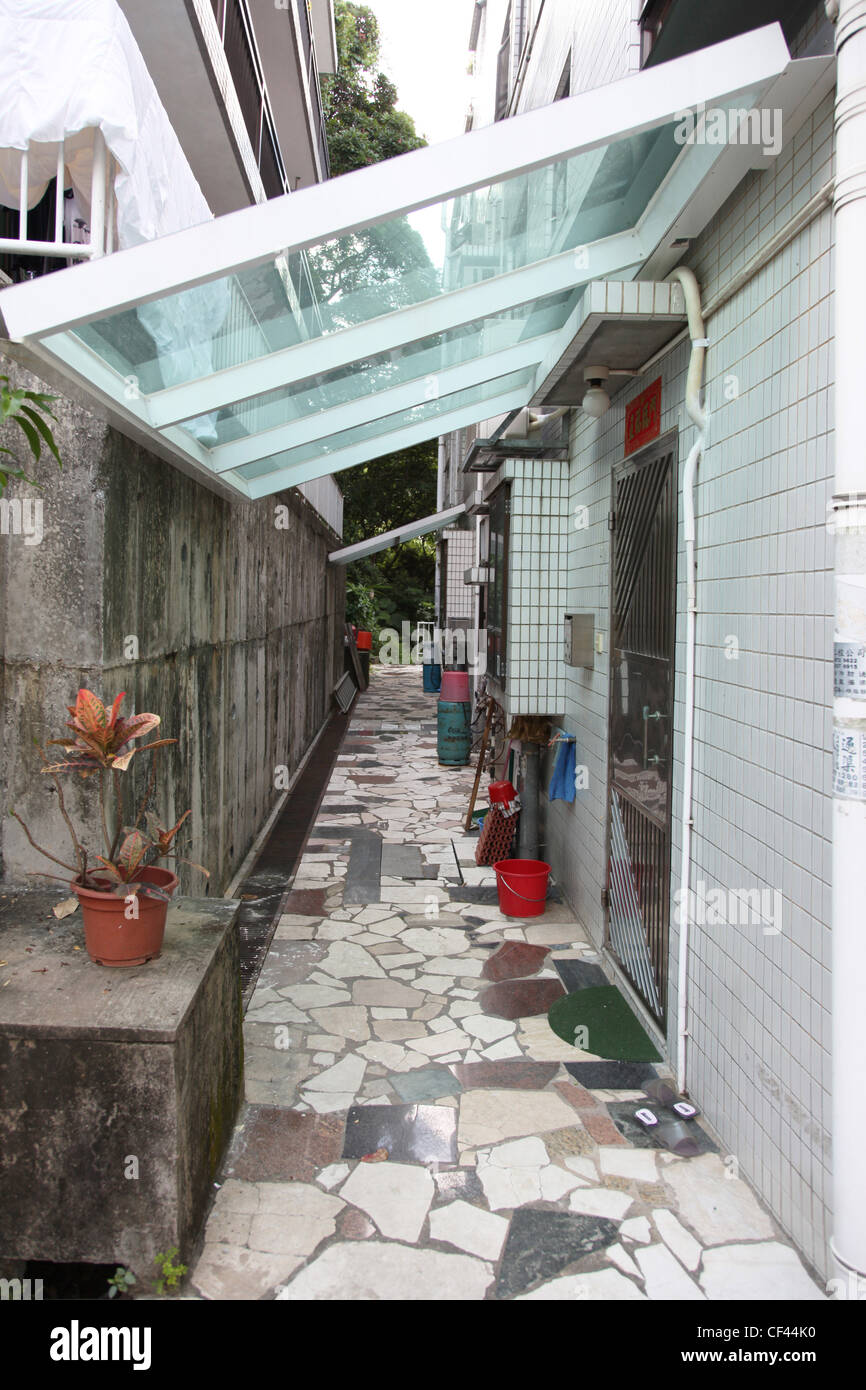 it's a small street in a hong kong village. there is tiles on the floor while th street is very narrow. Typical in  China Stock Photo