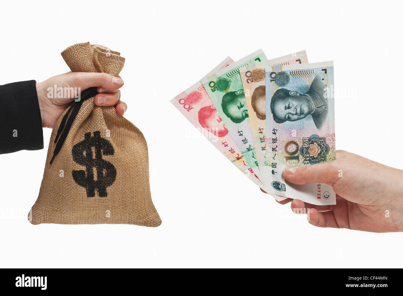 Diverse Chinese Yuan bills are held in the hand. At the other side a money bag with a U.S. Dollar currency sign held in the hand Stock Photo