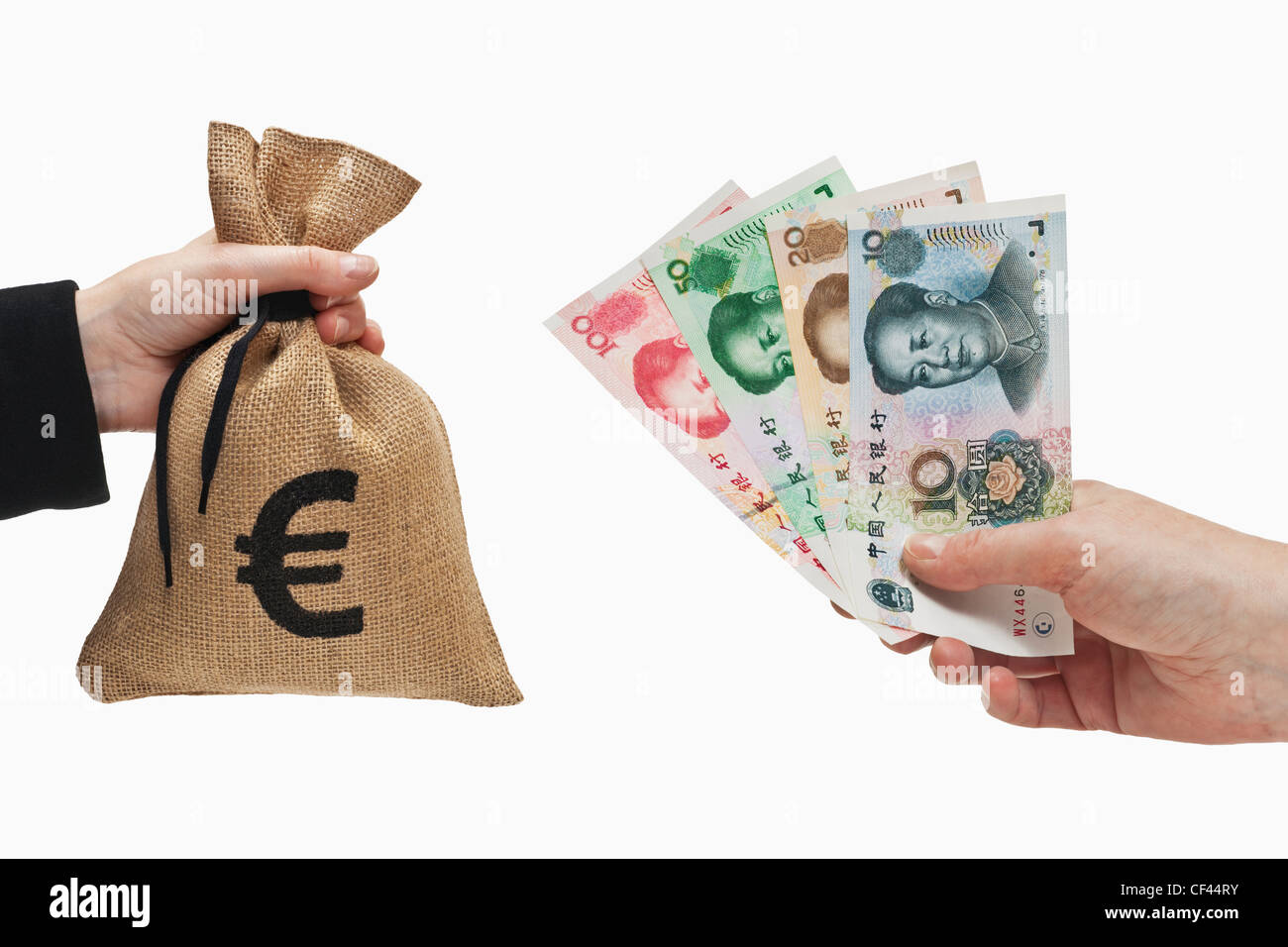 Diverse Chinese Yuan bills are held in the hand. At the other side a money bag with a Euro currency sign held in the hand. Stock Photo