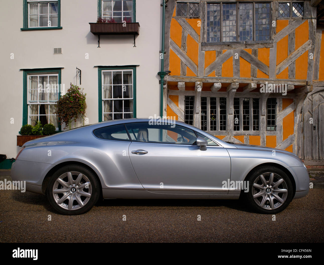 A modern Bentley motor car parked in front of timber framed buildings. Although built in Crewe and assumed to be a quintessentia Stock Photo