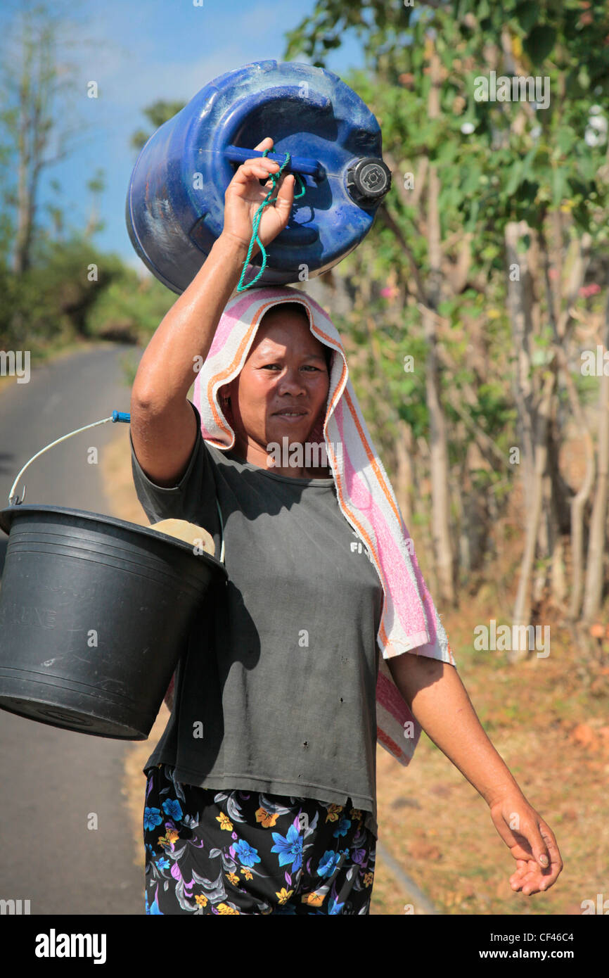 A Balinese woman with water buckets, Bali, Indonesia Stock Photo