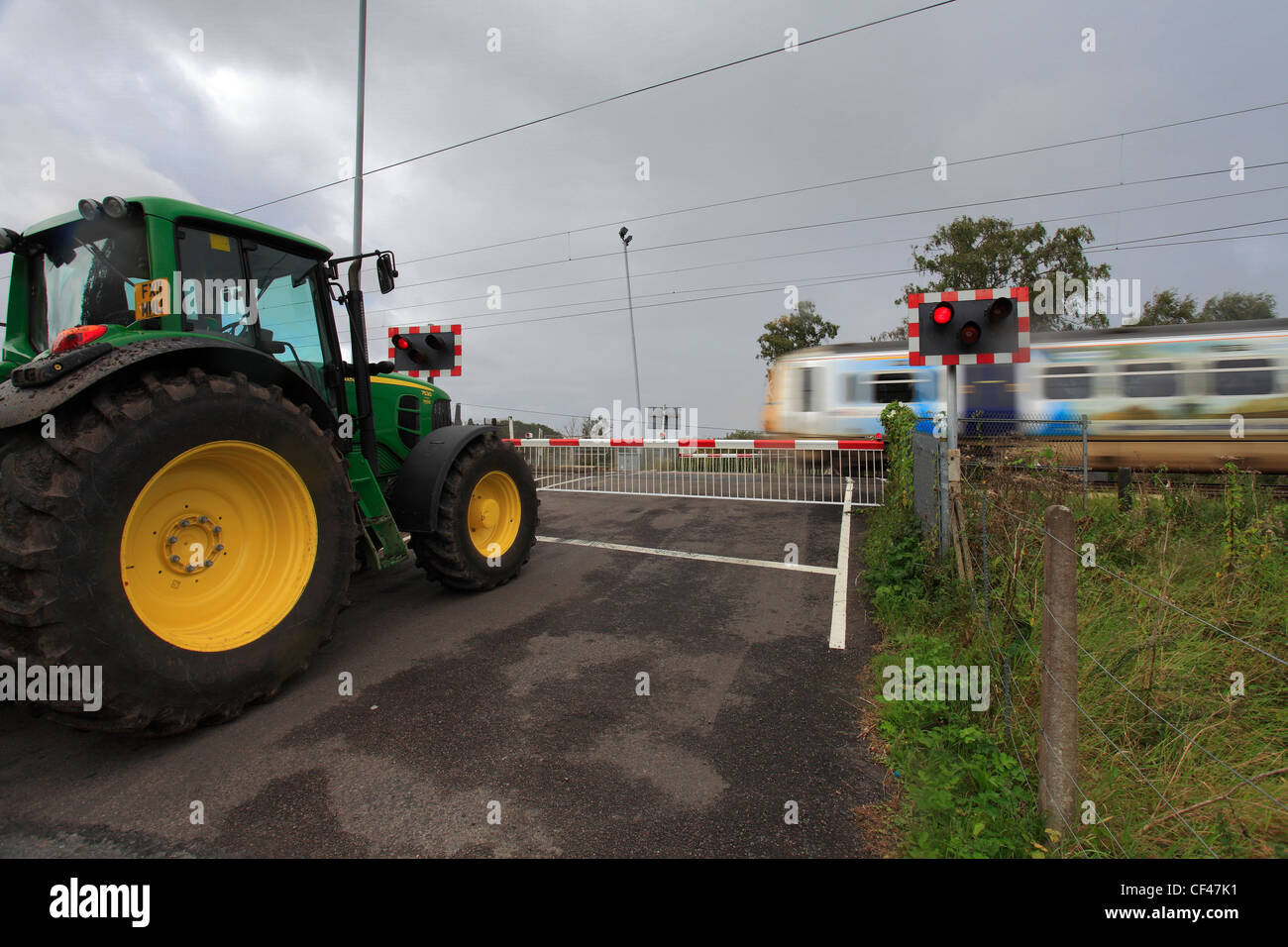 Speeding train at an unmanned Level Crossing, East Coast Main Line Railway, Cambridgeshire, England, UK Stock Photo